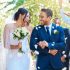 Wedding guests throwing rose petals confetti tradition over bride and groom on their special day. Newlywed couple walking past friends and family